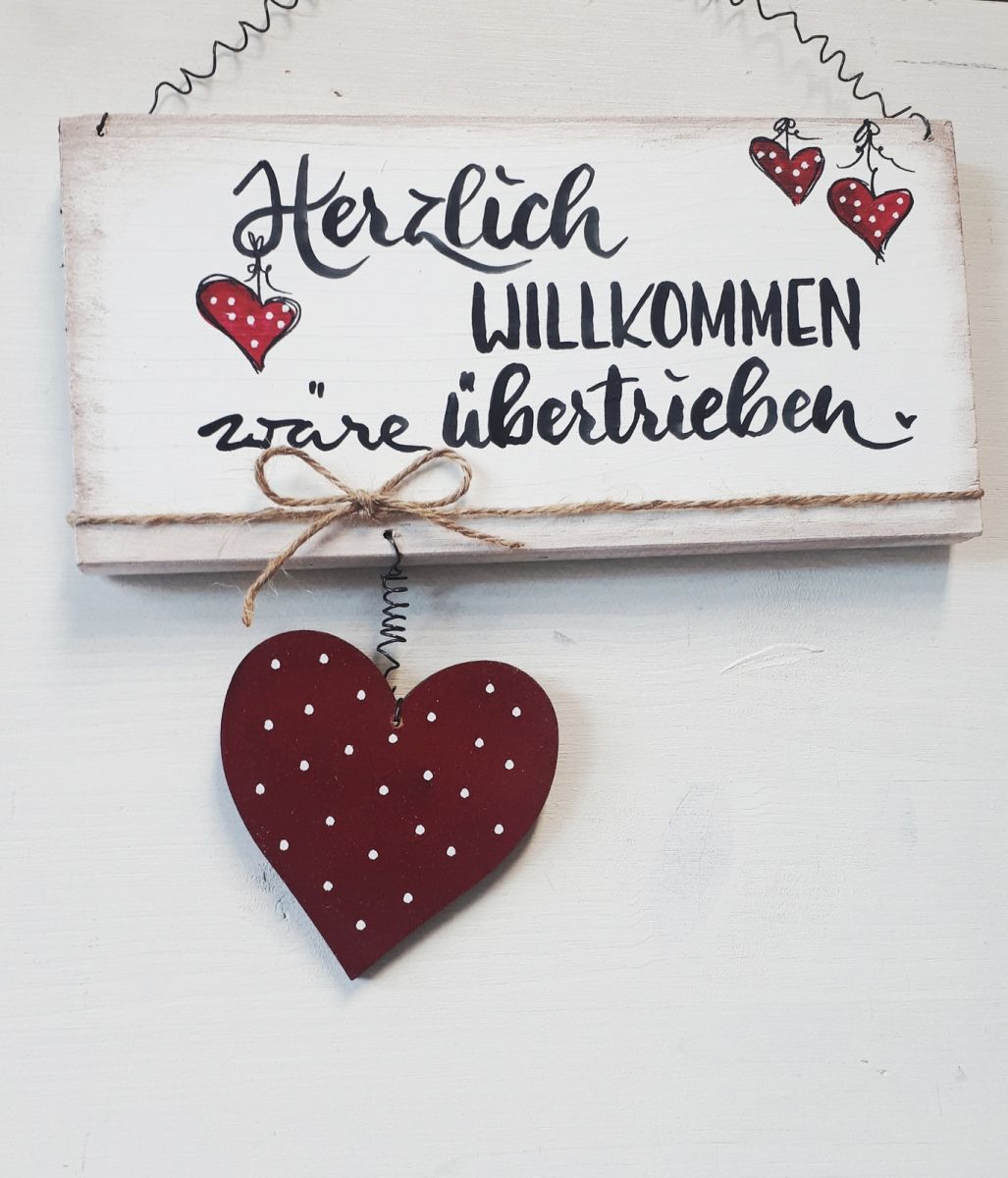 Schild cremeweiß mit Herzen und Aufschrift "Herzlich willkommen wäre übertrieben"